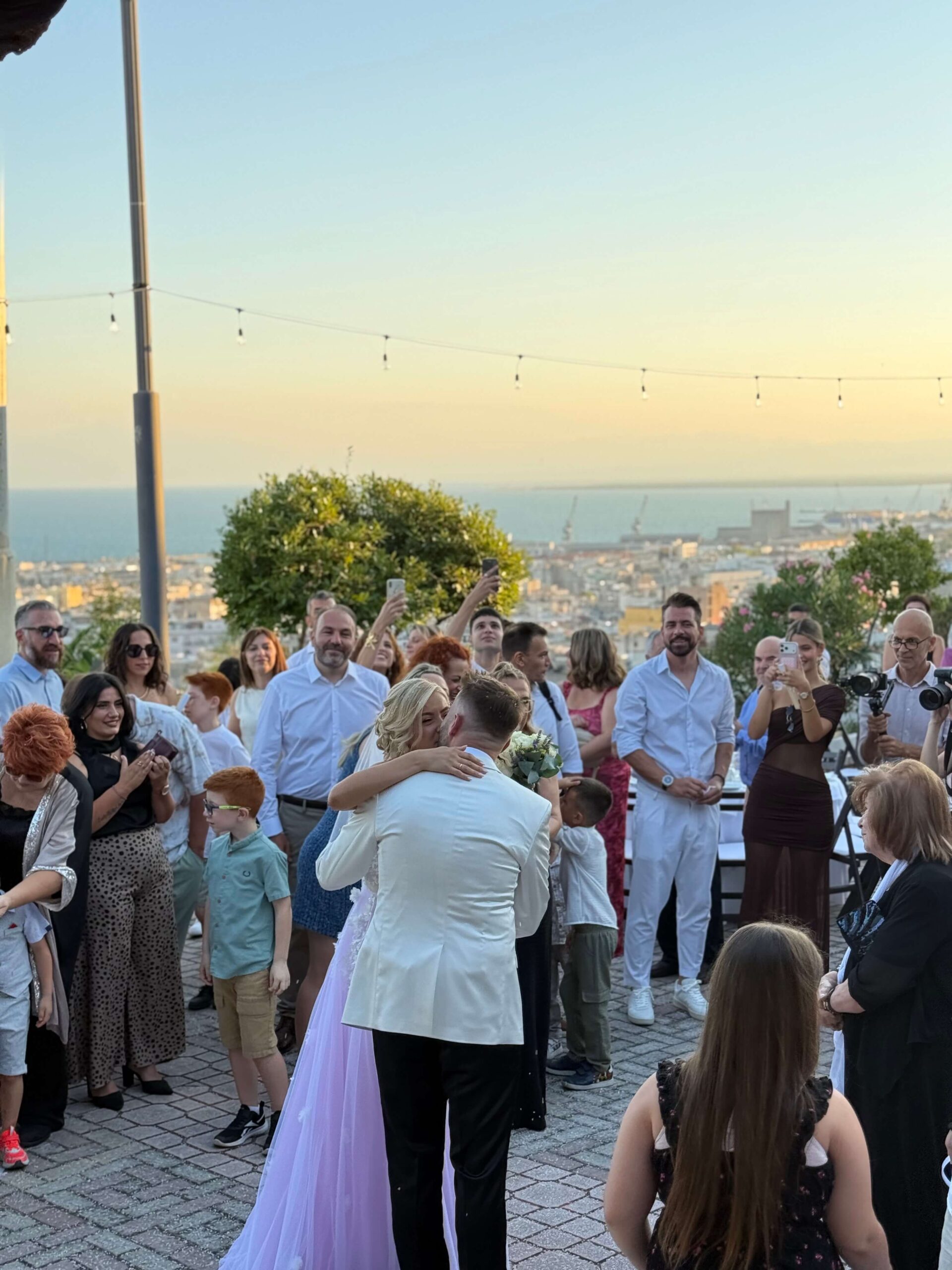 Guests celebrating together at an outdoor event overlooking the sea